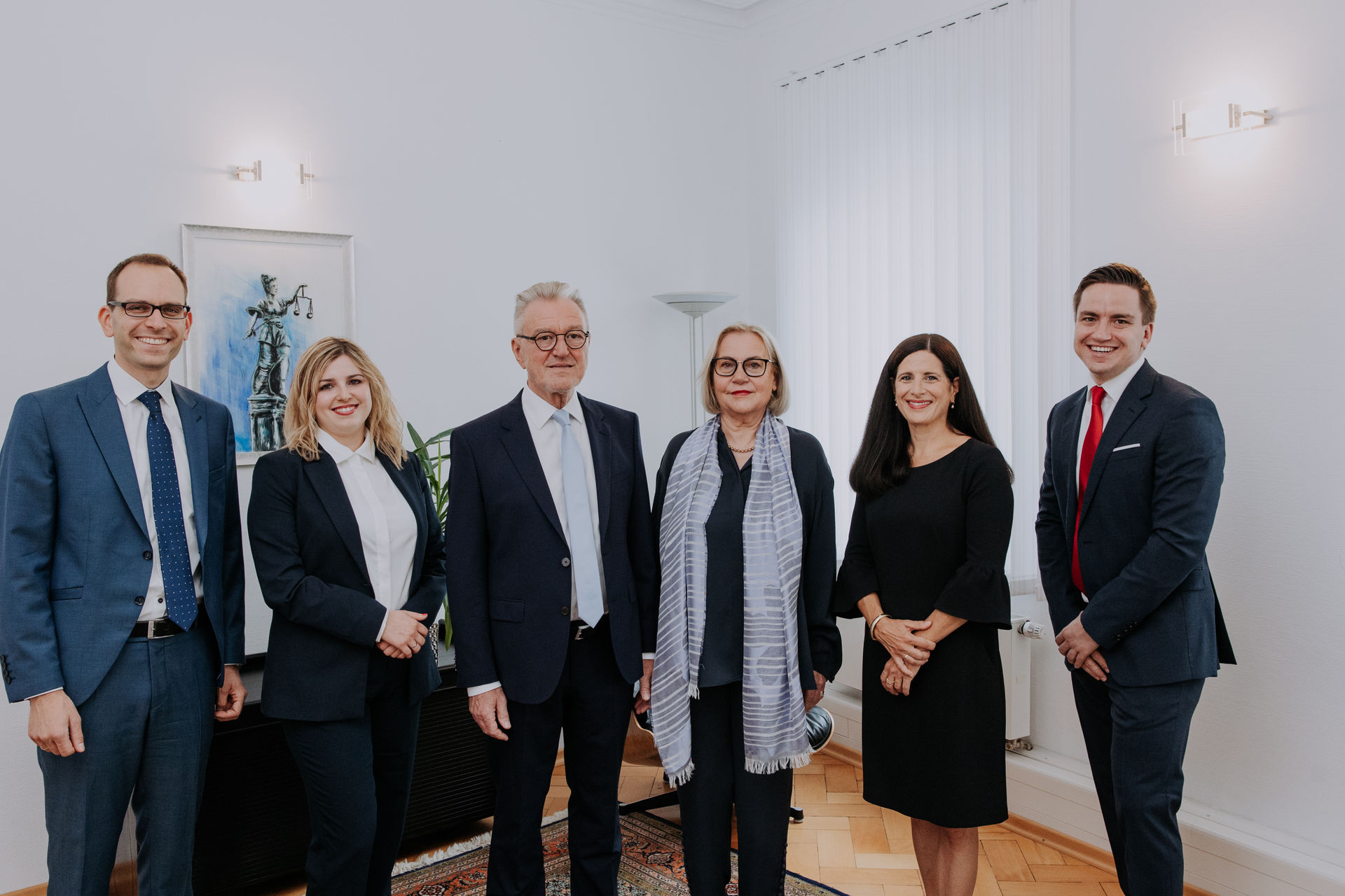 Gruppenfoto des Teams der Kanzlei Hauptmann-Uhl und Kollegen in einem hellen Kanzleiraum